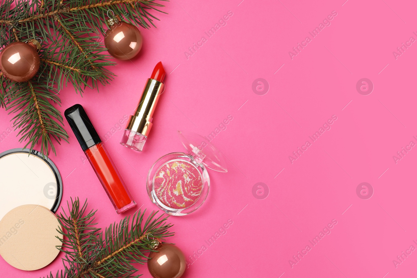 Photo of Flat lay composition with makeup products and Christmas decor on pink background. Space for text