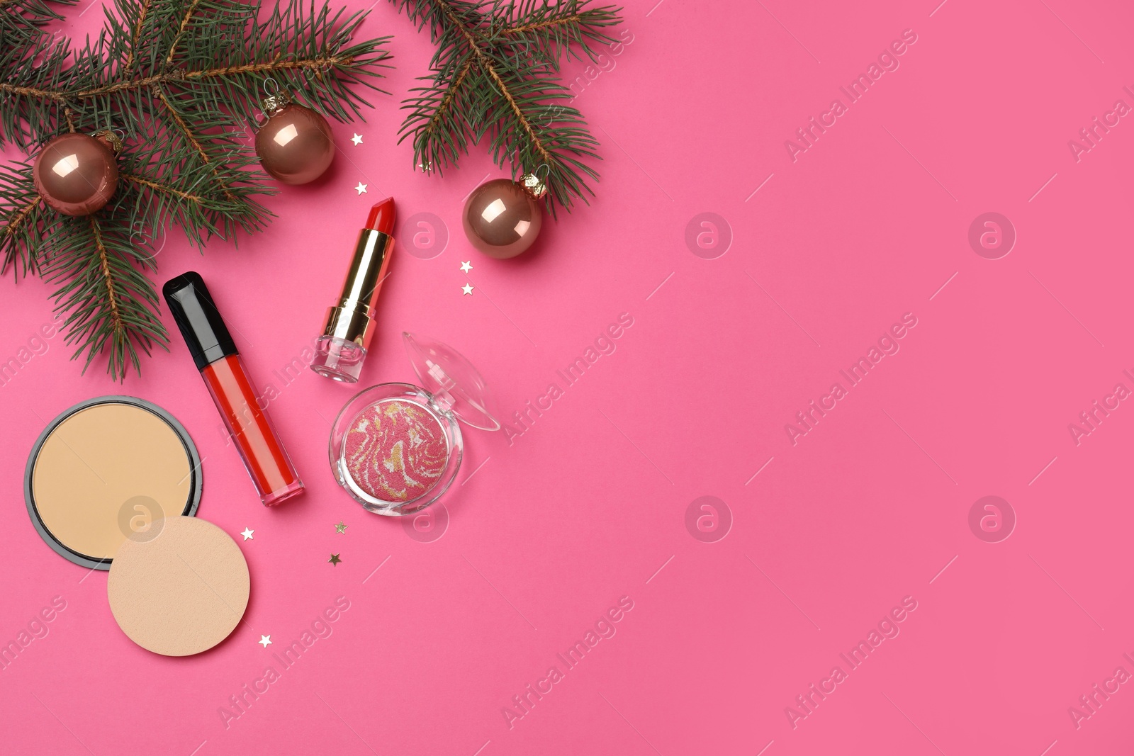 Photo of Flat lay composition with makeup products and Christmas decor on pink background. Space for text