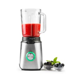 Photo of Blender with mixture of ingredients and fresh berries isolated on white