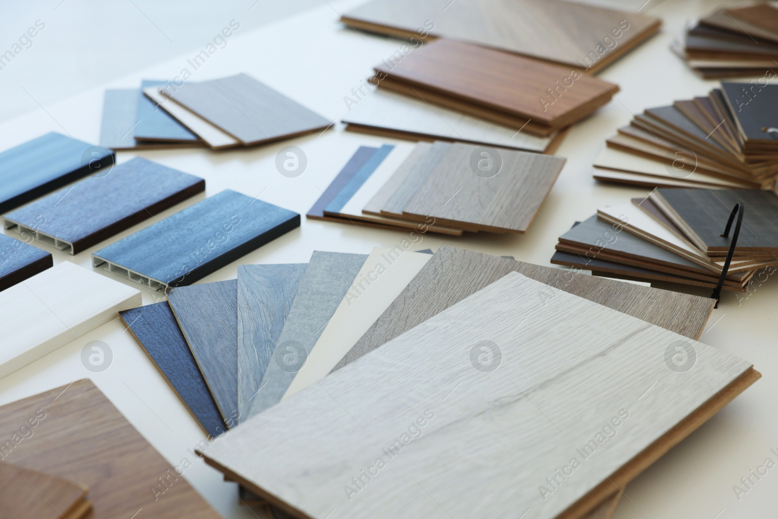 Photo of Different samples of wooden flooring on white table