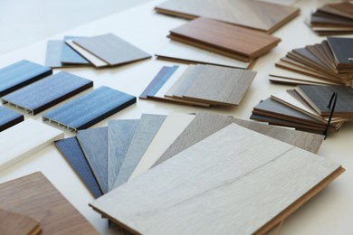 Photo of Different samples of wooden flooring on white table