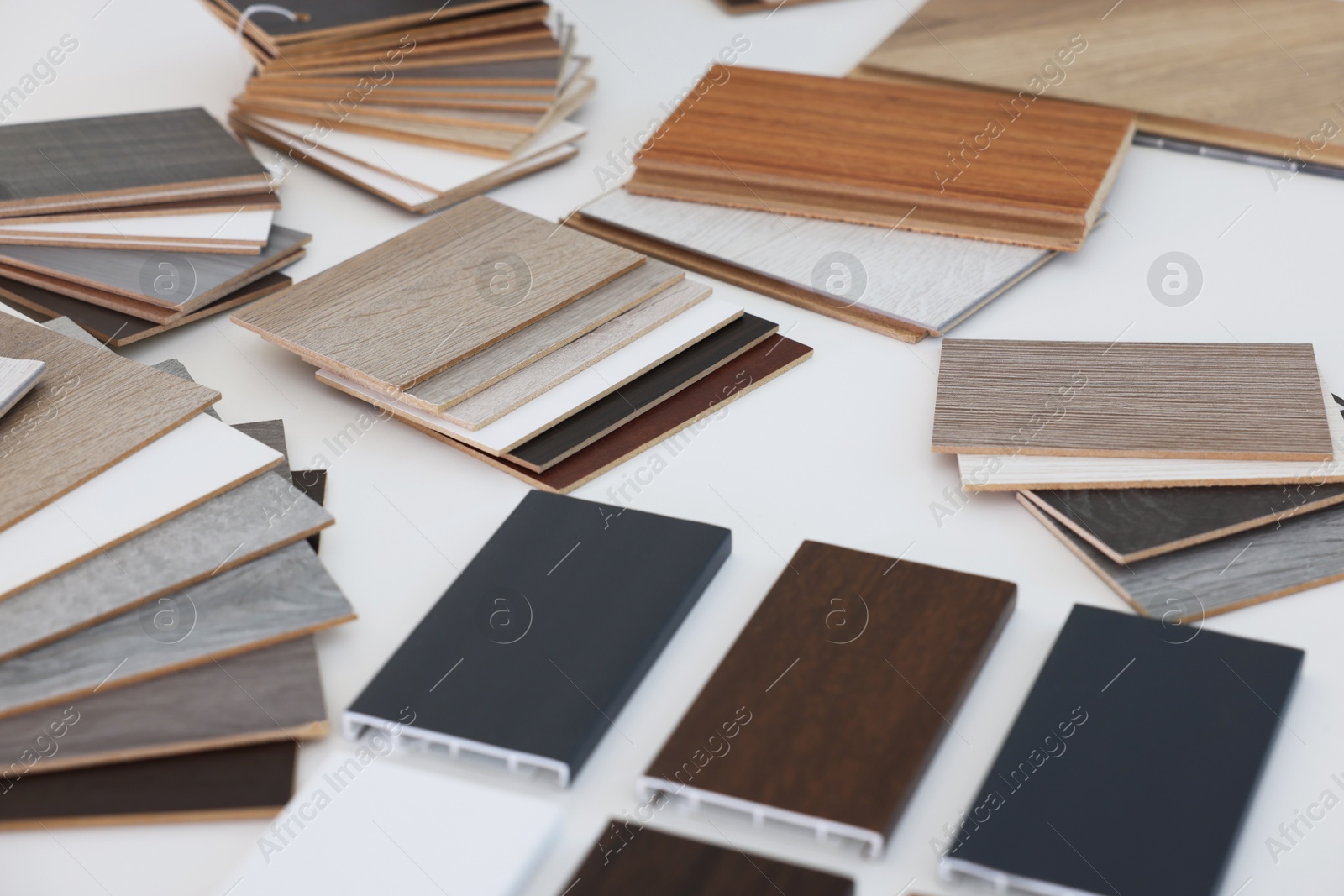 Photo of Different samples of wooden flooring on white table