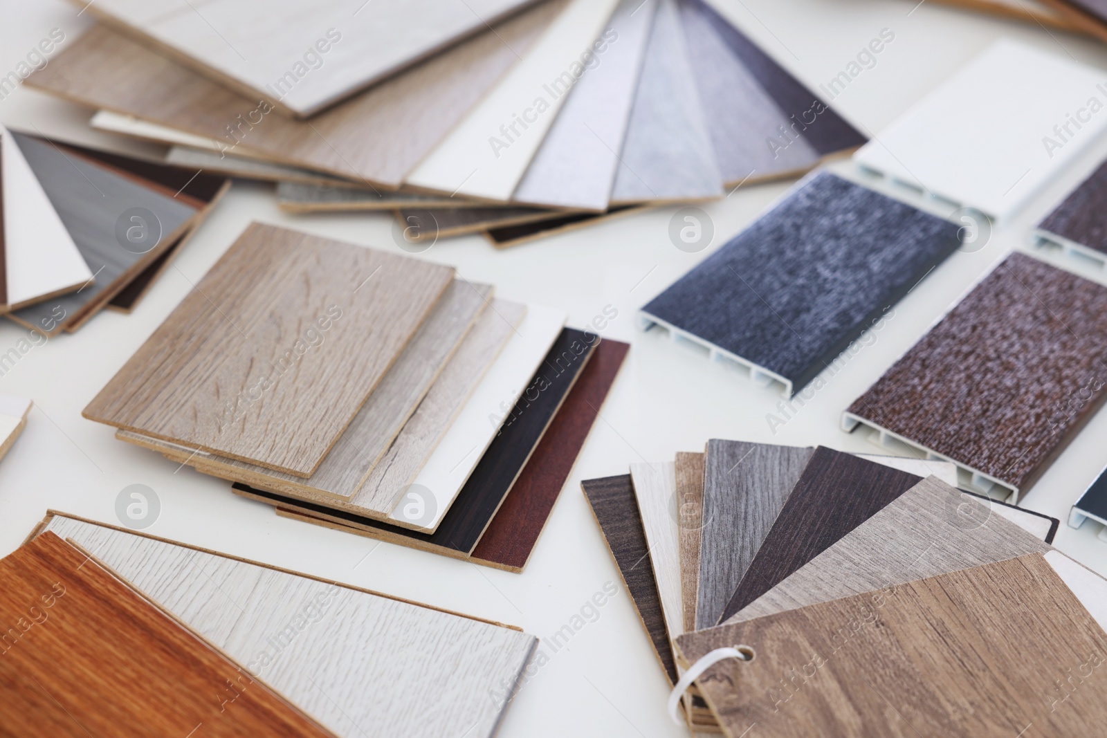 Photo of Different samples of wooden flooring on white table