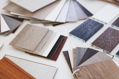 Photo of Different samples of wooden flooring on white table