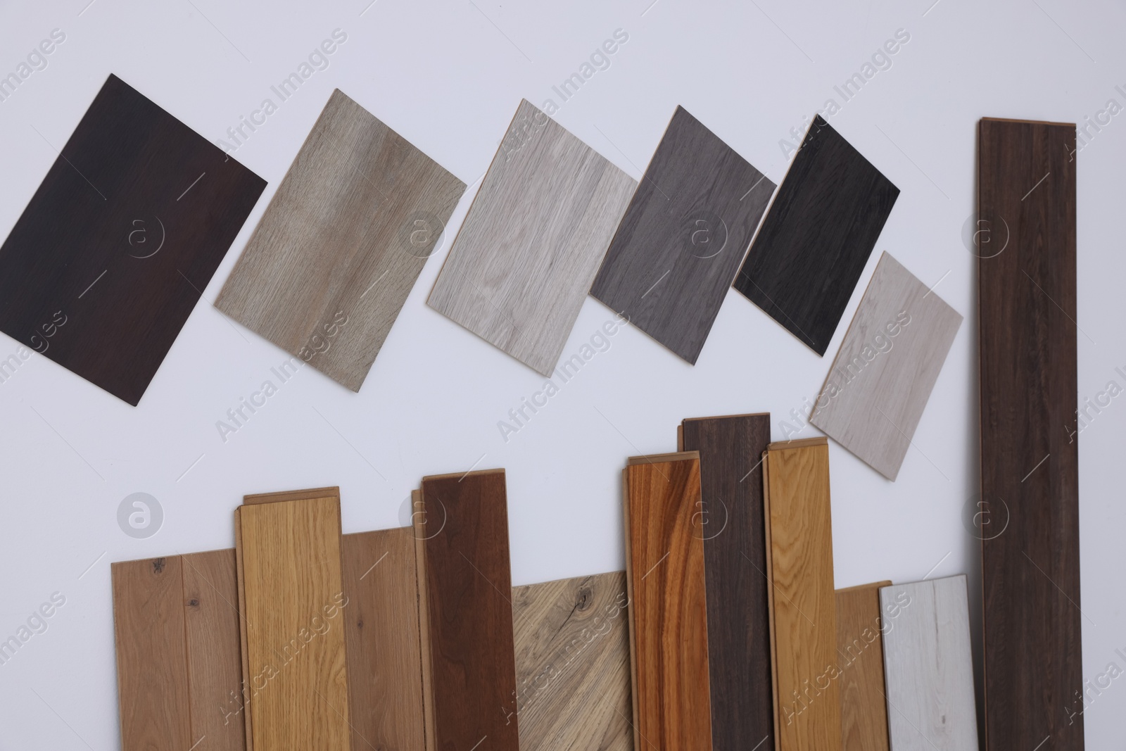 Photo of Many different samples of wooden flooring on light background