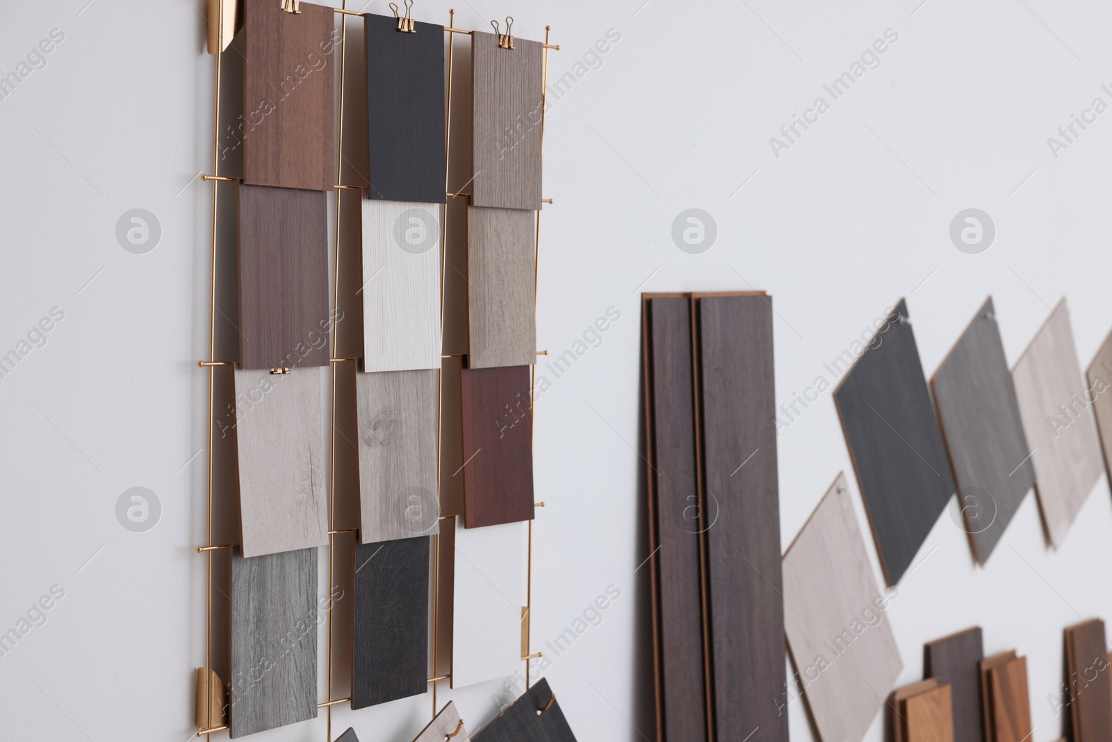 Photo of Many different samples of wooden flooring on light background