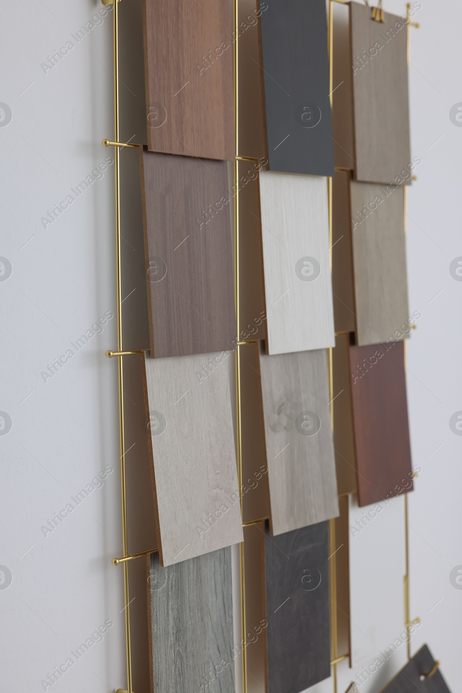 Photo of Many different samples of wooden flooring on light background