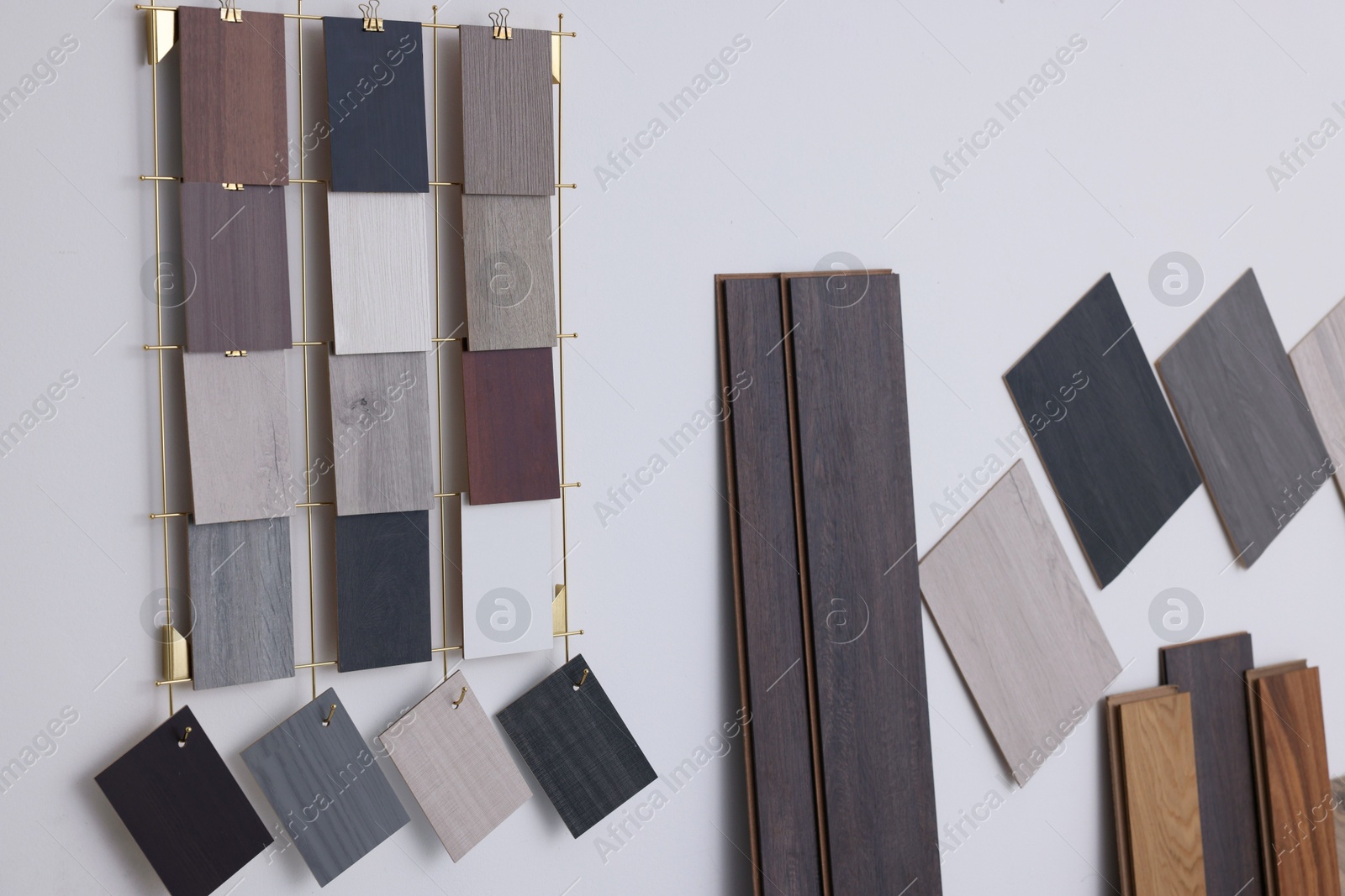 Photo of Many different samples of wooden flooring on light background