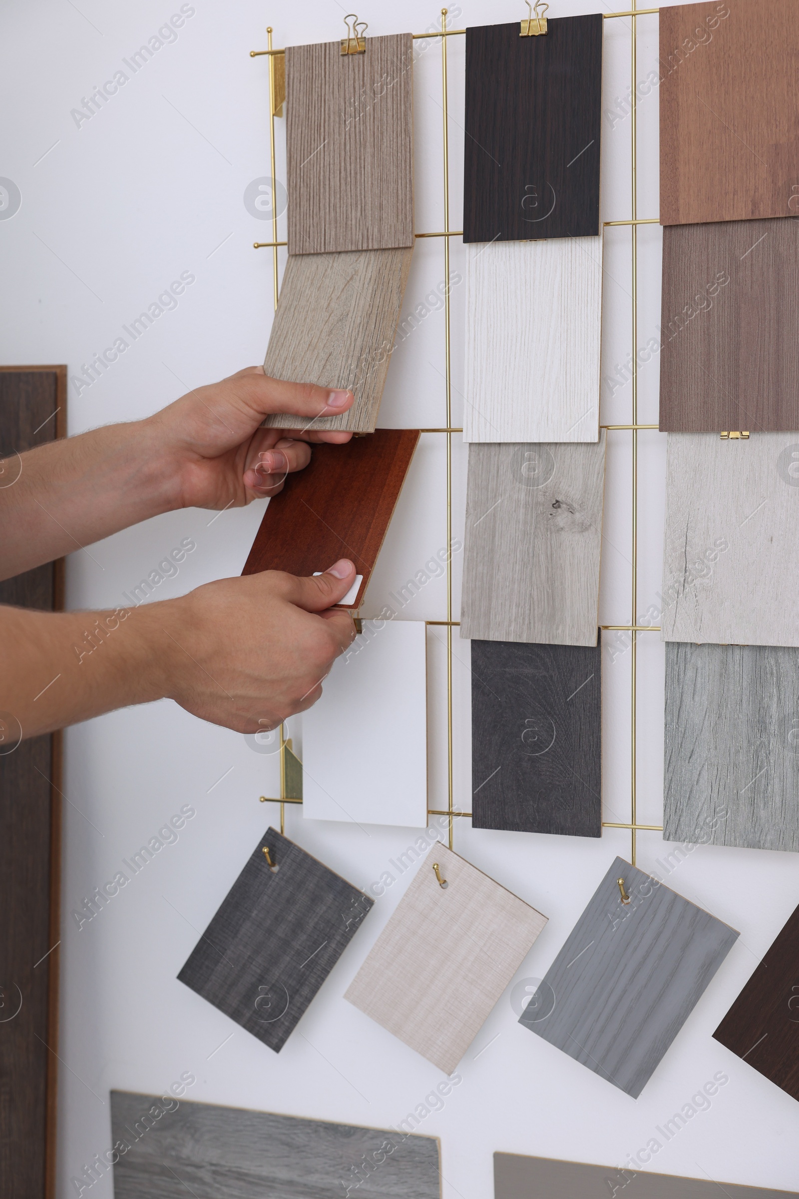 Photo of Man with different samples of wooden flooring indoors, closeup