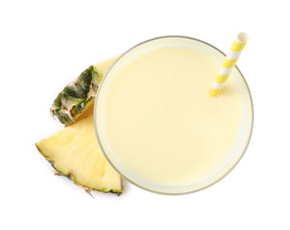 Photo of Tasty pineapple smoothie in glass and slices of fruit isolated on white, top view