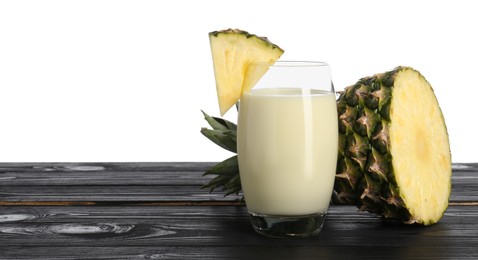 Photo of Tasty pineapple smoothie in glass and slices of fruit on wooden table against white background. Space for text