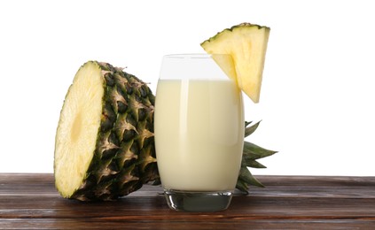 Photo of Tasty pineapple smoothie in glass and slices of fruit on wooden table against white background