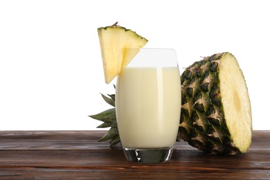 Photo of Tasty pineapple smoothie in glass and slices of fruit on wooden table against white background. Space for text