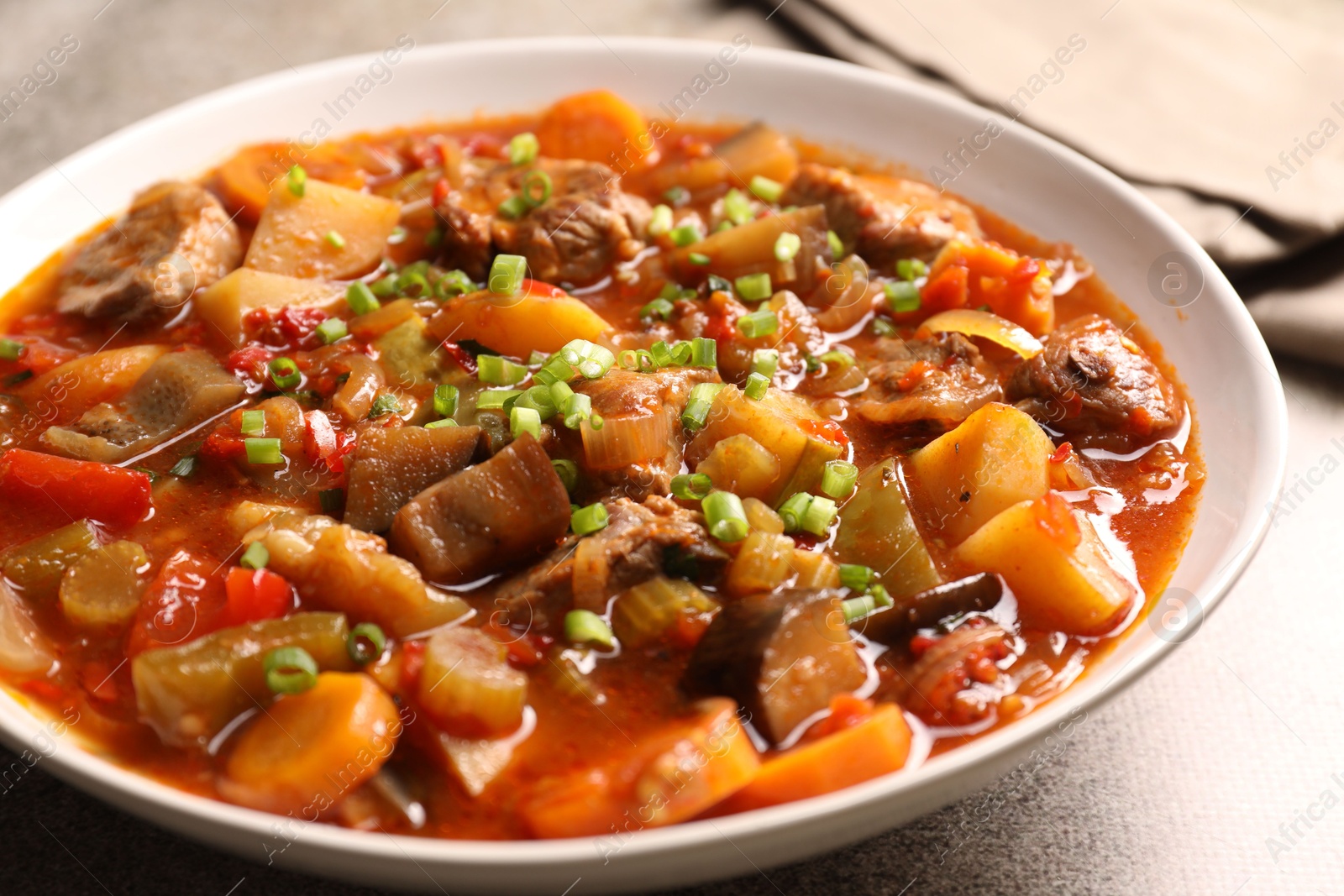 Photo of Delicious stew with vegetables in bowl on table, closeup