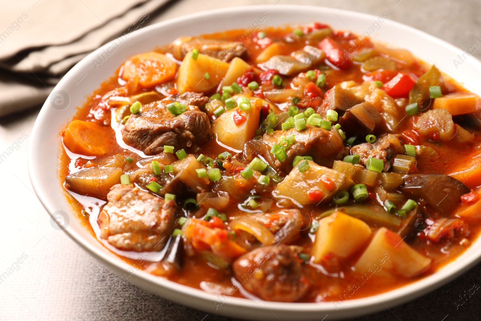 Photo of Delicious stew with vegetables in bowl on table, closeup