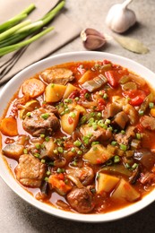 Photo of Delicious stew with vegetables in bowl on table, closeup