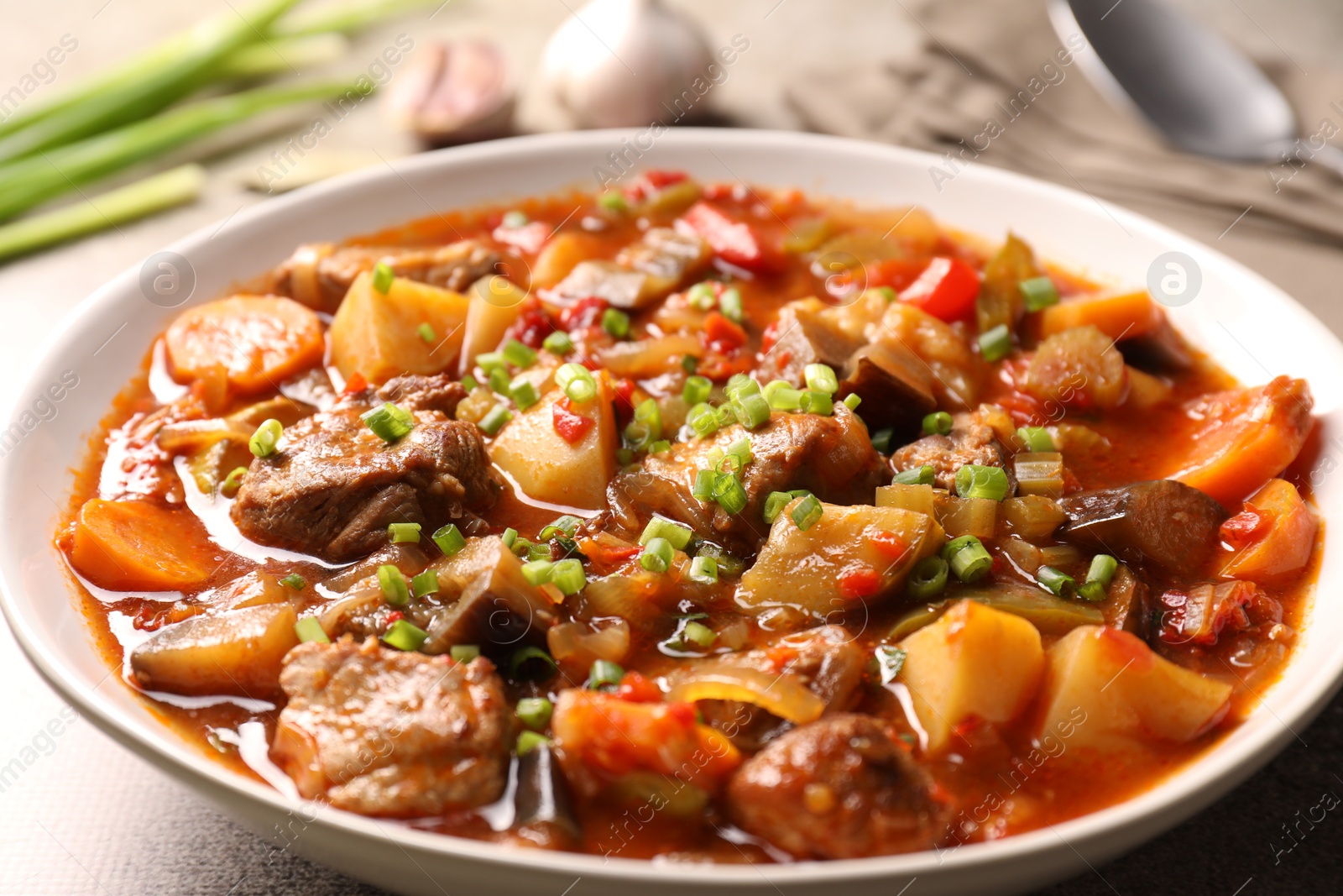 Photo of Delicious stew with vegetables in bowl on table, closeup