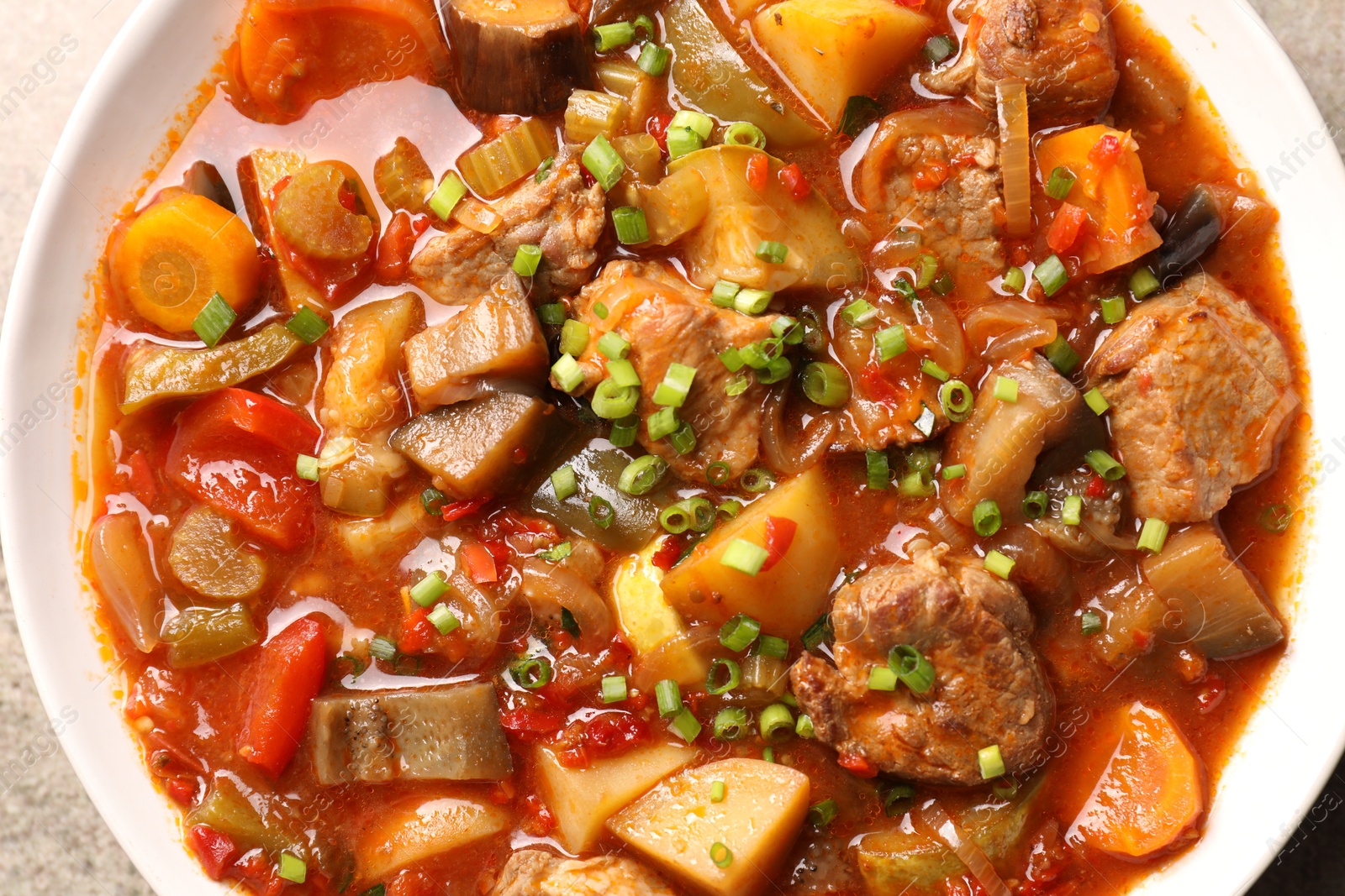 Photo of Delicious stew with vegetables in bowl on table, top view