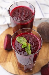 Photo of Fresh beetroot smoothie in glasses on table, closeup