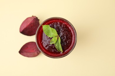 Photo of Fresh beetroot smoothie with mint in glass on beige background, top view. Space for text