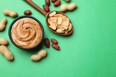 Photo of Tasty peanut butter and groundnuts on green background, flat lay. Space for text