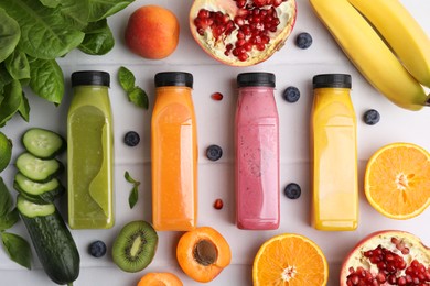 Photo of Glass bottles of tasty smoothies and different products on white tiled table, flat lay