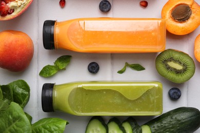 Glass bottles of tasty smoothies and different products on white tiled table, flat lay