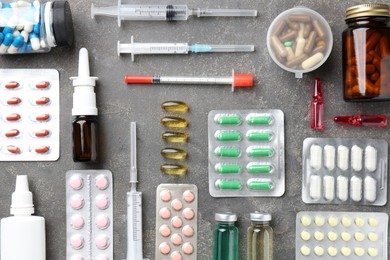 Photo of Pharmacist. Different pills, syringes, bottles of medical drops and ampoules on grey table, flat lay