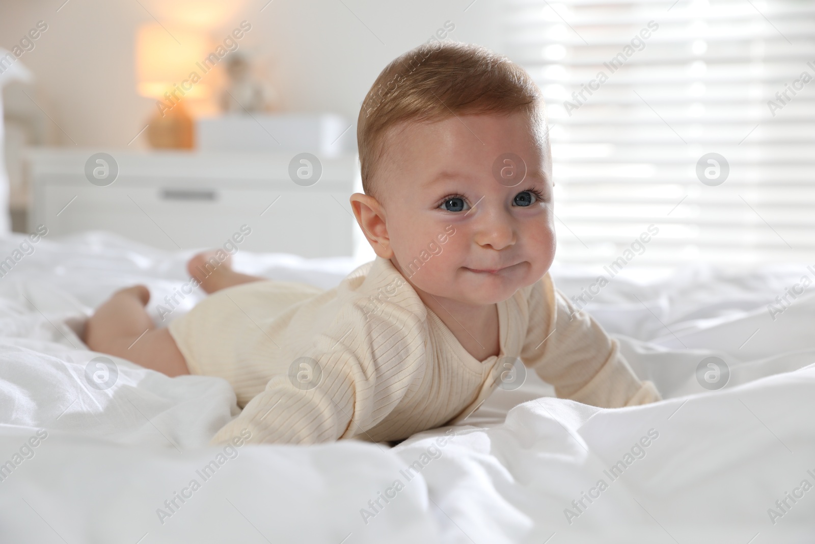 Photo of Cute little baby on bed at home