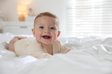 Cute little baby on bed at home, space for text