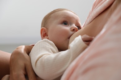 Mother breastfeeding her little baby indoors, closeup