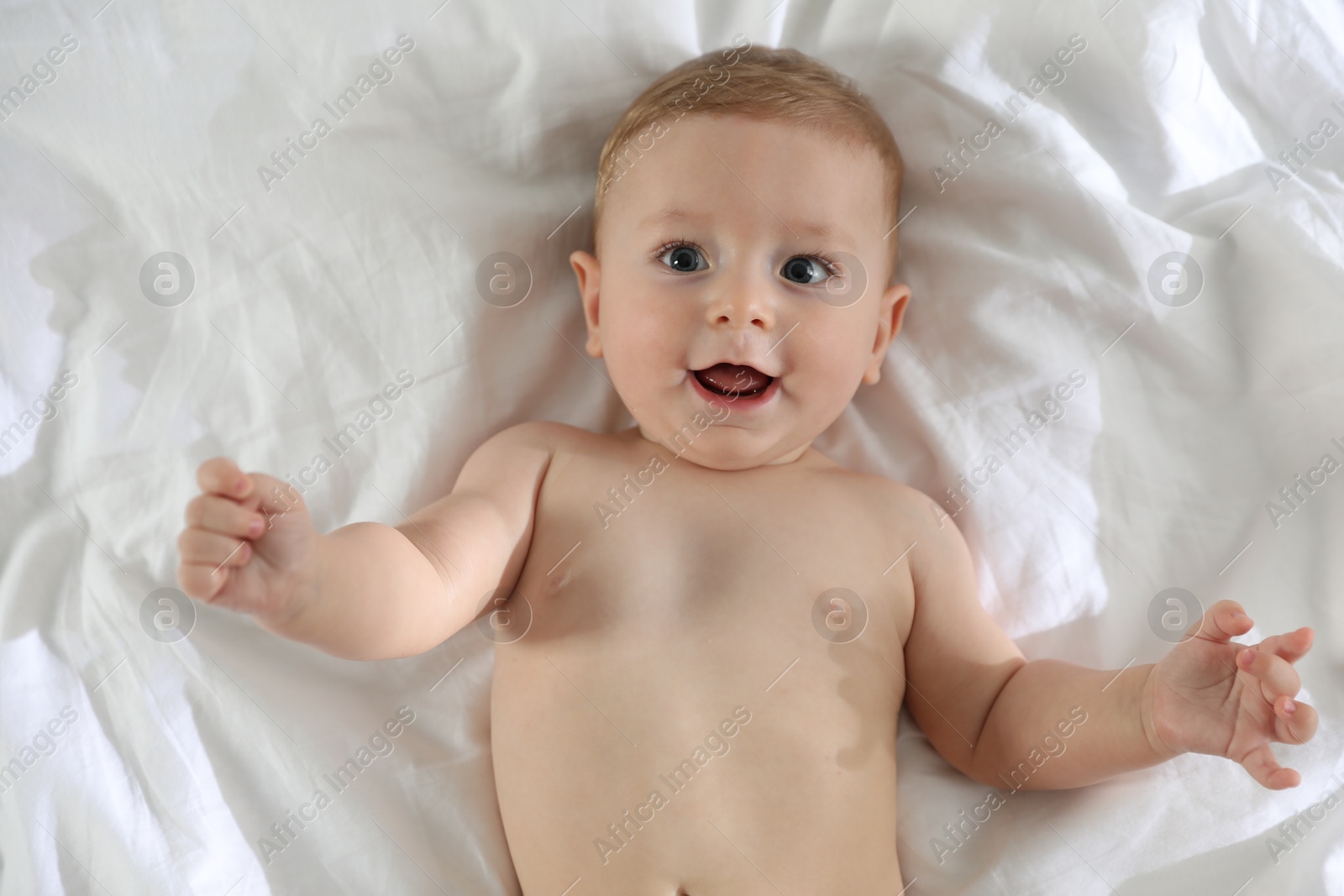 Photo of Cute little baby on bed at home, top view