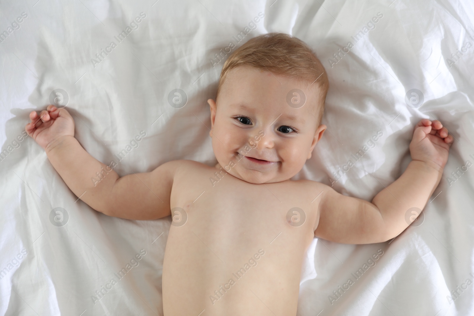 Photo of Cute little baby on bed at home, top view