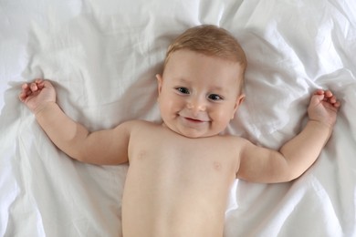 Cute little baby on bed at home, top view