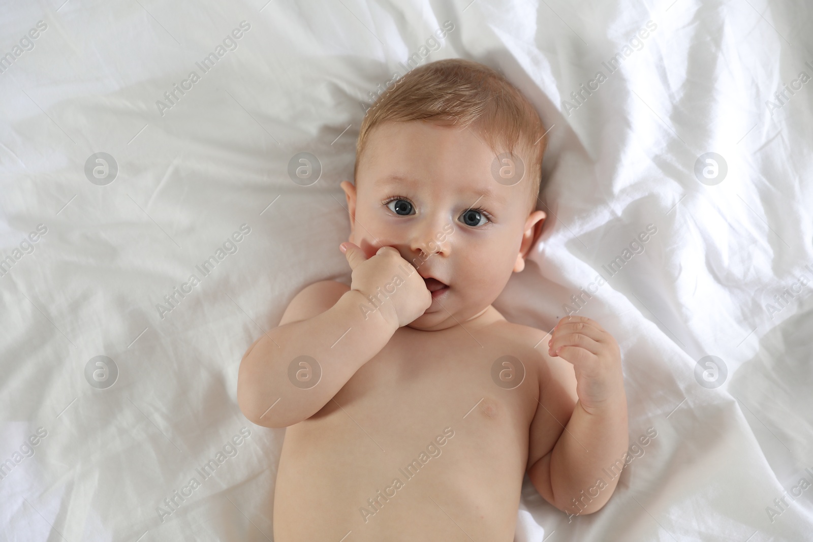 Photo of Cute little baby on bed at home, top view