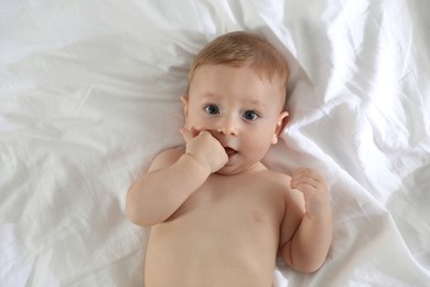 Cute little baby on bed at home, top view