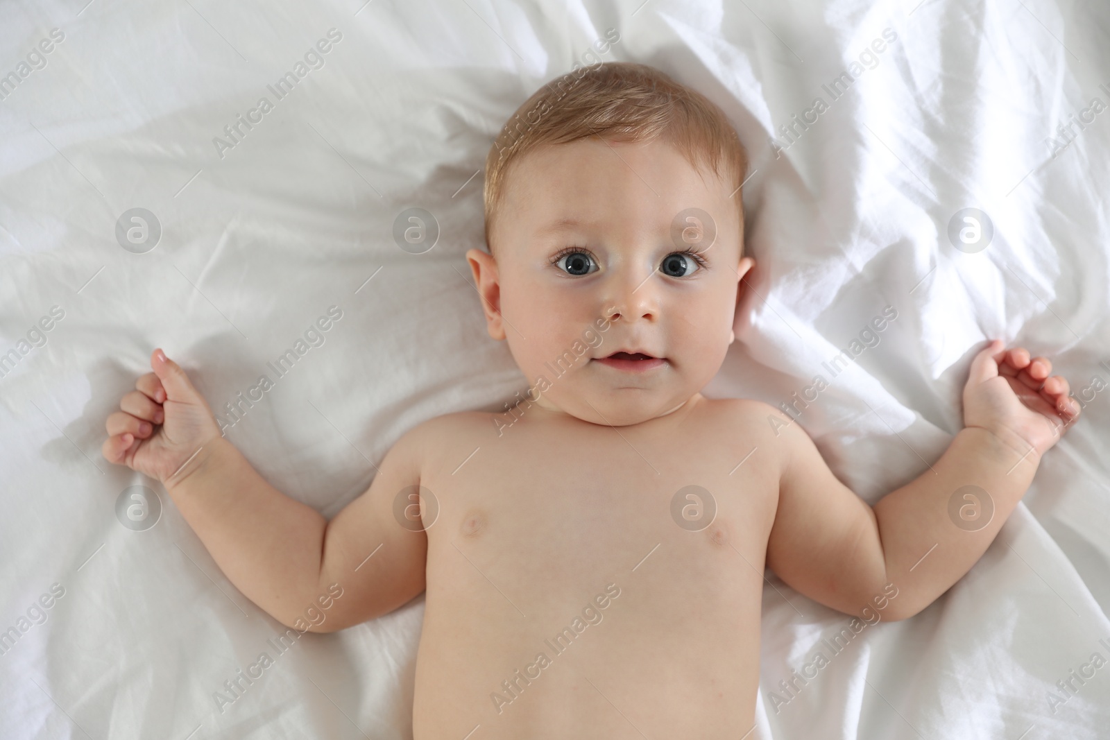 Photo of Cute little baby on bed at home, top view