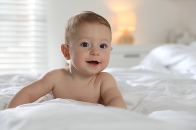 Cute little baby on bed at home, space for text