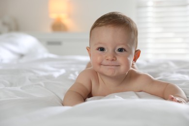 Photo of Cute little baby on bed at home, space for text