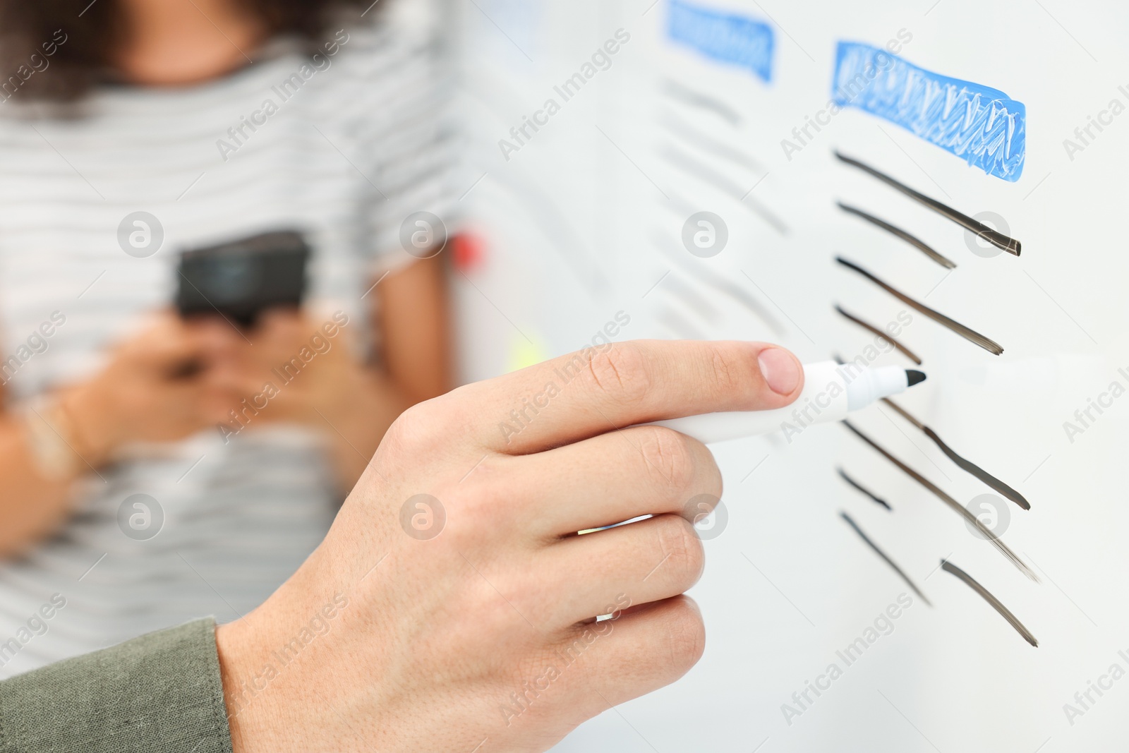 Photo of Developing UI design. Man and woman drawing website wireframe on whiteboard indoors, closeup