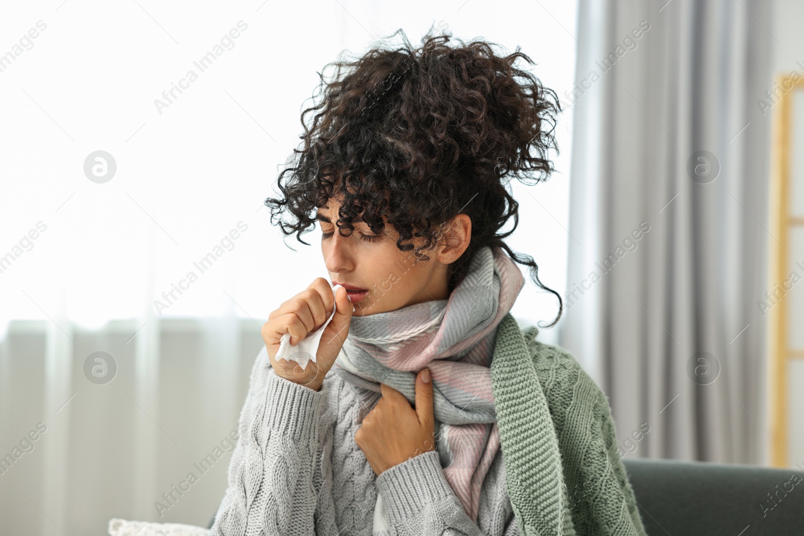 Photo of Cold symptom. Young woman with tissue at home