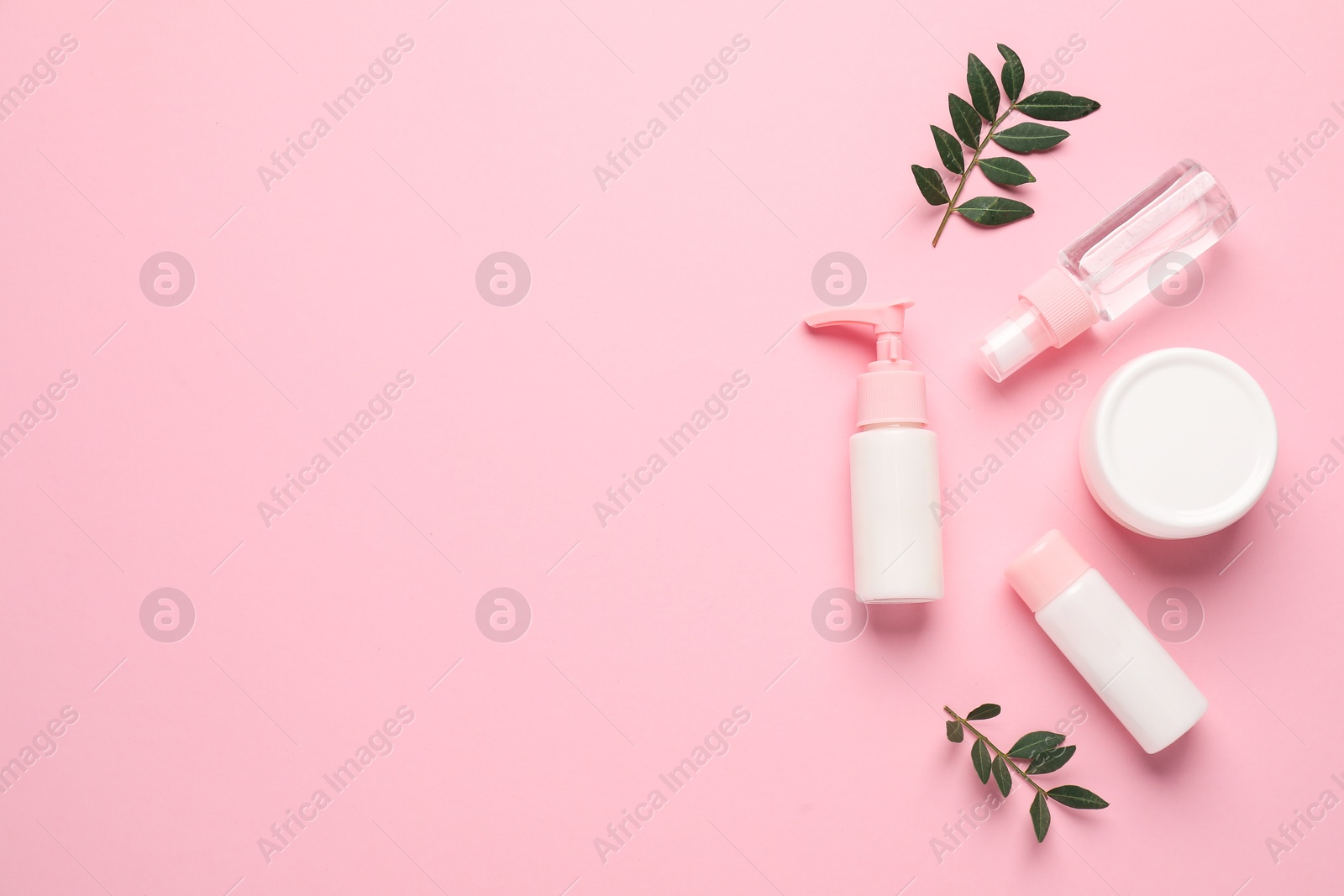 Photo of Different cosmetic products and leaves on pink background, flat lay. Space for text