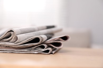 Photo of Stack of newspapers in different languages on table indoors. Space for text