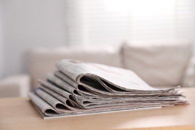 Photo of Stack of newspapers in different languages on table indoors