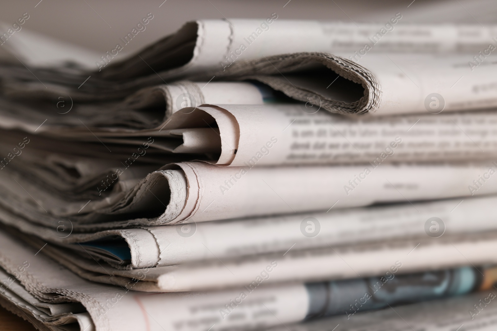 Photo of Many newspapers in different languages as background, closeup