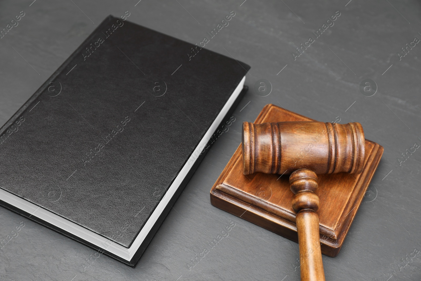 Photo of Book and judge's gavel on gray textured table