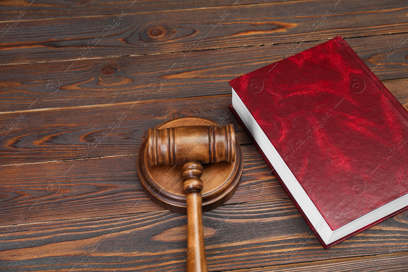 Photo of Book and judge's gavel on wooden table, space for text