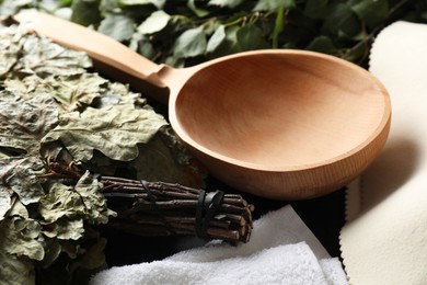 Sauna whisks, felt wool hat and wooden ladle on table, closeup