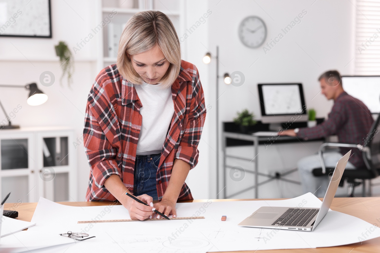 Photo of Architect making engineering drawing at table in office