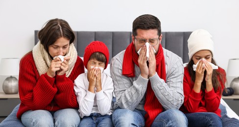 Photo of Cold symptom. Family suffering from fever on bed at home